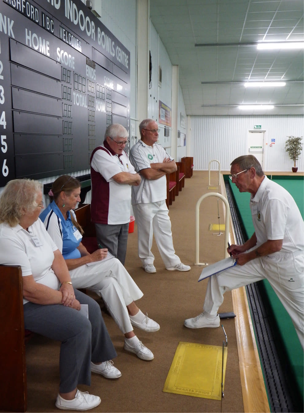 An EBCS coach working with a group of bowlers at an indoor session